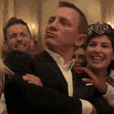 a man in a suit is being touched by a woman in a headband