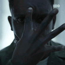 a close up of a man covering his face with his hand with the hbo logo in the corner