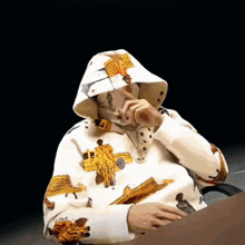 a person wearing a white hoodie with a picture of a man on it