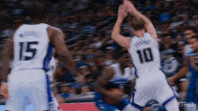 a blurry picture of a basketball game with players number 15 and 10 in the foreground