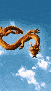 a golden dragon is flying through a blue sky with white clouds