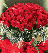a large bouquet of red roses with baby 's breath and a crown on top
