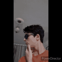 a young man wearing sunglasses and an orange shirt with the word power director on the bottom right