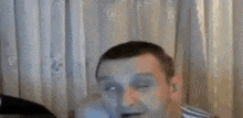 a blurry picture of a person standing in front of a white curtain