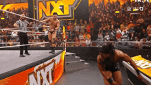 a man in a wrestling ring with the word nxt in the background