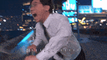 a man in a white shirt and tie is screaming in front of a blurry city background