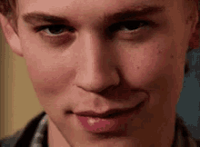 a close up of a young man 's face with a smile on it .