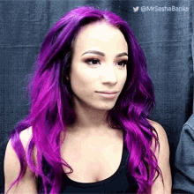 a woman with purple hair wearing a black tank top