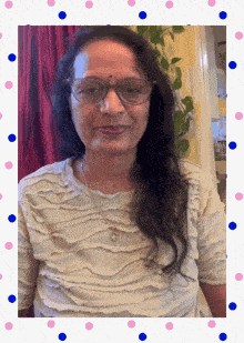a woman wearing glasses and a necklace is surrounded by polka dots