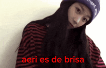 a woman wearing a striped shirt and a purple hat says aeri es de brisa in red letters