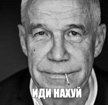a black and white photo of an elderly man with a cigarette in his mouth .