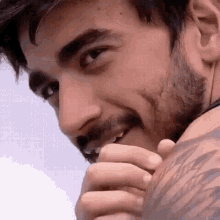 a man with a beard and a tattoo on his arm