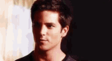 a close up of a man 's face with a black shirt on looking at the camera .