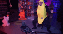 a man in a banana costume is dancing in front of a microphone in a dark room .