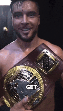 a shirtless man is holding a belt that says get