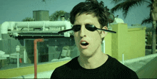 a man wearing sunglasses with a spoon attached to his ear