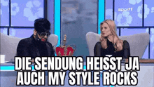 a man and a woman are sitting next to each other on a couch on a tv show .