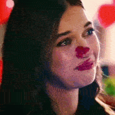 a woman with a red nose is making a face