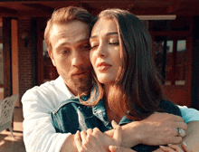 a man and woman are hugging each other with the woman wearing a ring on her finger