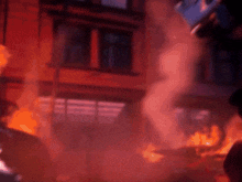 a cartoon character is standing in front of a building that is burning .