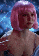 a woman wearing a pink wig is pointing