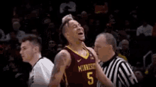 a basketball player wearing a minnesota jersey celebrates with his fist in the air .