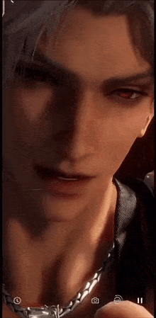 a close up of a man 's face wearing a chain around his neck .