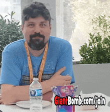 a man sitting at a table with a giantbomb.com/join advertisement