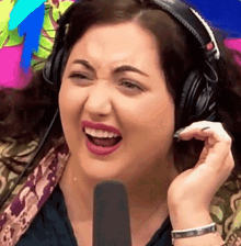 a woman wearing headphones is laughing with her mouth wide open