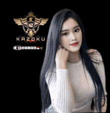 a woman in a white sweater stands in front of a logo for kazoku
