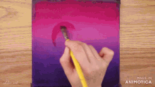 a person is painting a pink and purple gradient with a brush