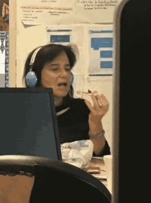 a woman wearing headphones eating a piece of pizza
