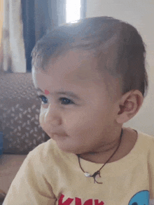 a baby with a red spot on his forehead is smiling