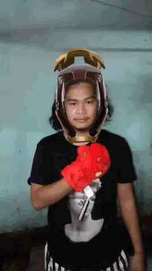 a man wearing a helmet and a red glove is holding a gun