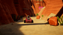a red vehicle is driving through a desert canyon