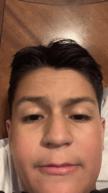 a close up of a young man 's face with his eyes closed and his mouth open