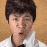 a close up of a young man making a surprised face .