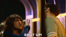 a woman is telling a man to shut up while standing next to him .