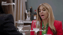 a woman says i was just bored with it while sitting at a table with wine glasses