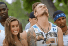 a group of people are standing in a line and one of them is wearing a blue bandana