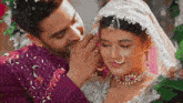 a man putting a ring on the nose of a bride