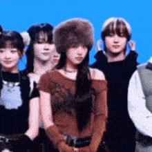 a group of people are standing next to each other and one of them is wearing a fur hat .