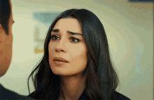 a woman is crying while looking at a man