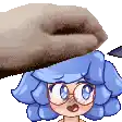 a cartoon girl with blue hair and glasses is being held by a person 's hand .