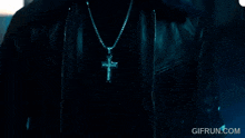 a close up of a person wearing a cross necklace with gifrun.com in the corner