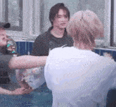 a group of people are standing in a swimming pool holding a donut .
