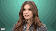 a woman with a scarf around her neck and the words popbuzz meets behind her