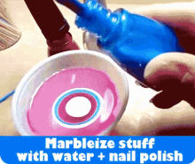 a bottle of blue nail polish is being poured into a cup of pink liquid