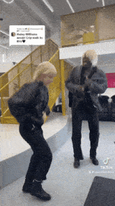 a man and a woman are dancing in front of a yellow railing and stairs