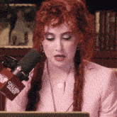 a woman with red hair and a microphone that says call her daddy on it